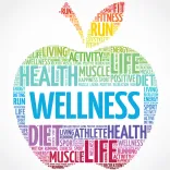 A colorful apple shape made of words related to health and wellness, including "WELLNESS," "HEALTH," and "DIET," in various fonts and colors.
