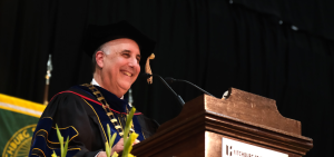 President Lapidus smiles at podium at Grad Commencement Spring 2024