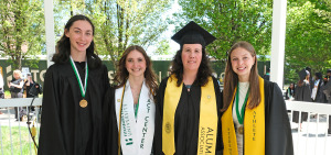 Graduates with their first-grade teacher at commencement