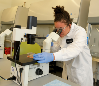 Alumna Crystal McKinnon at microscope