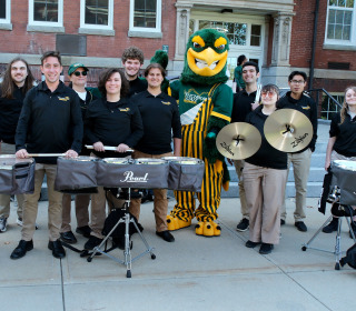 Drumline posing with Freddy in front of Edgerly.