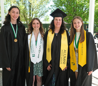 Graduates with their first-grade teacher at commencement