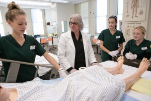 Students care for a patient in a nursing classroom 