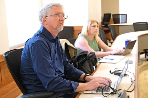 Faculty Academy - Sean Goodlett lead at table with laptop 