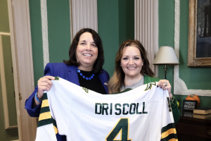 Lt. Gov. Driscoll poses with commemorative Falcons jersey presented by President Hodge