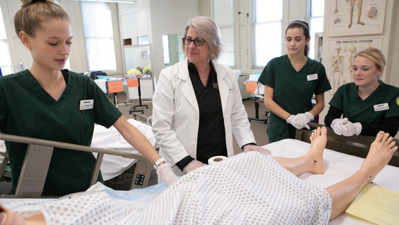 Students care for a patient in a nursing classroom