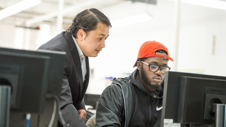 Engineering professor Nirajan Mani and student at computer in classroom
