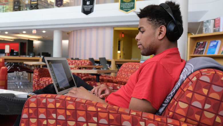 Student using laptop in campus library