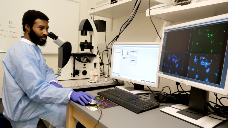 Student working with microscope in science building