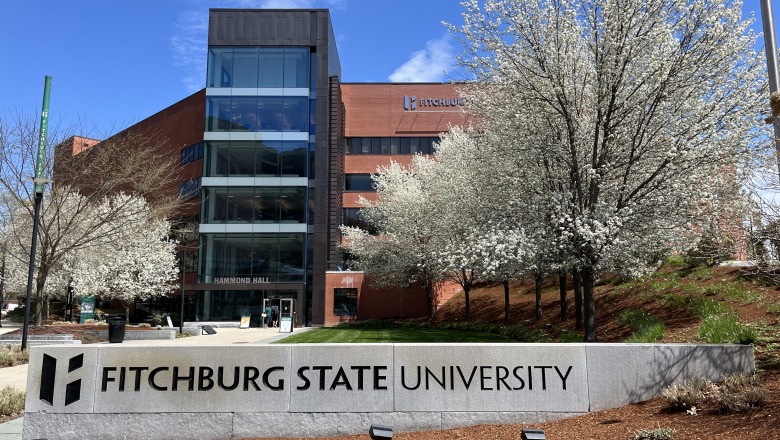 Front of Hammond Hall with sign and white flower trees