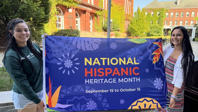 Krysta and student holding National Hispanic Heritage Month flag on alumni quad before flag raising