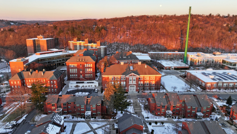 Aerial quad at sunrise in winter with snow on ground and moon in sky