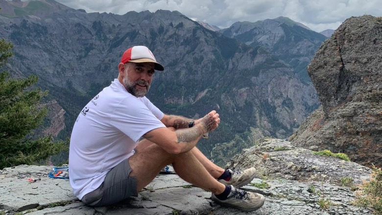 Jeff Godin sitting on the top of a mountain