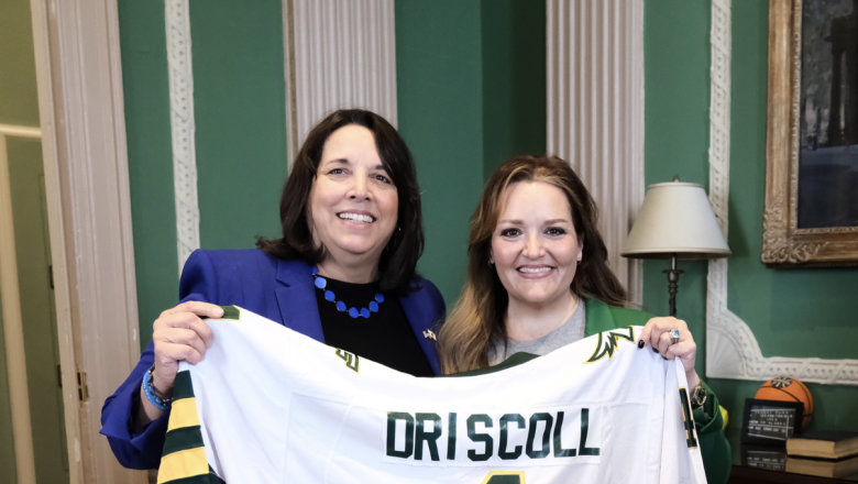 Lt. Gov. Driscoll poses with commemorative Falcons jersey presented by President Hodge