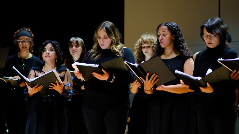 Group of females singing on stage in Weston Auditorium. 