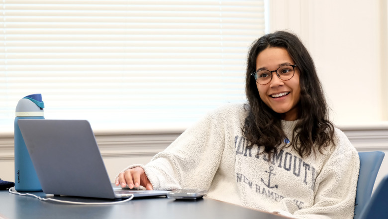 Human services student smiling in classroom with laptop