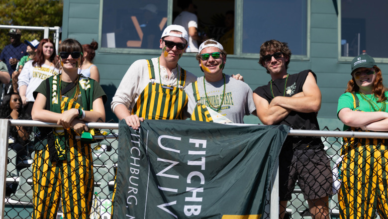 Homecoming students in the bleachers at the football game