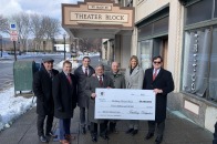 Leaders pose with check for theater block renovations