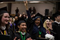 Male and female graduates smiling and celebrating at winter commencement