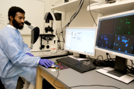 Student working with microscope in science building