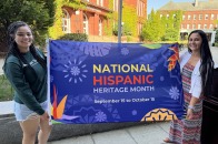 Krysta and student holding National Hispanic Heritage Month flag on alumni quad before flag raising