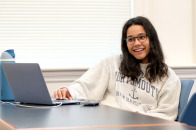 Human services student smiling in classroom with laptop