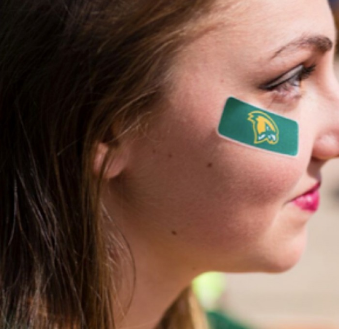A sideways shot of a woman with a Fitchburg State flag painted on her cheek