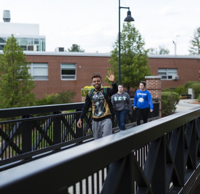 Student waves at the camera