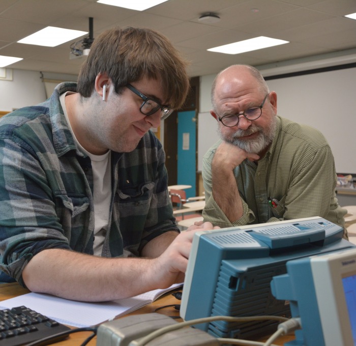 Computer Science Student looking at old computer
