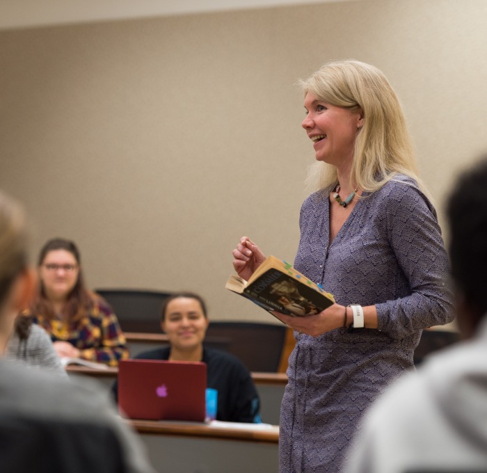 Professor Katy Covino holds book during lecture