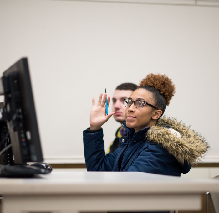 Student raises her hand in computer science class