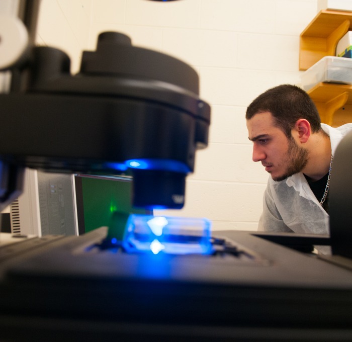 student with microscope