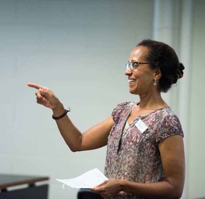 A teacher points encouragingly to a student 