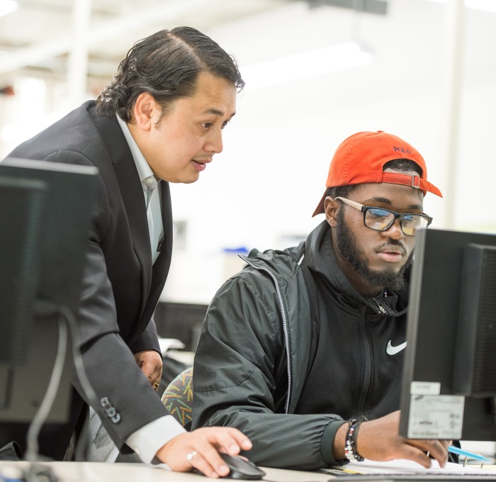 Engineering professor and student at computer in classroom