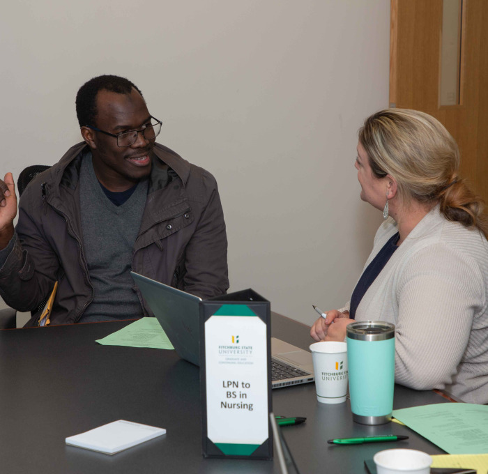 Graduate student and advisor at table at info session