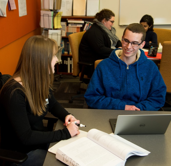 Counselor and student at table in counseling center with laptop