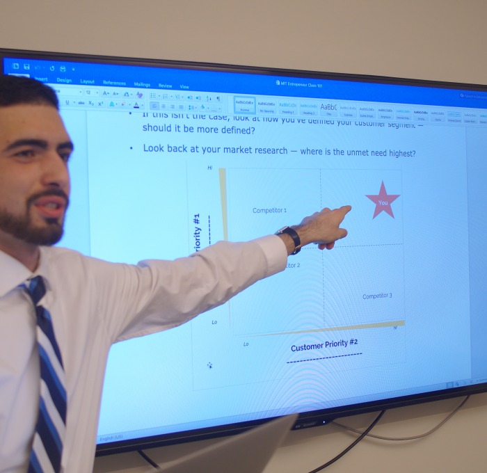 Business student pointing to white board during his presentation 