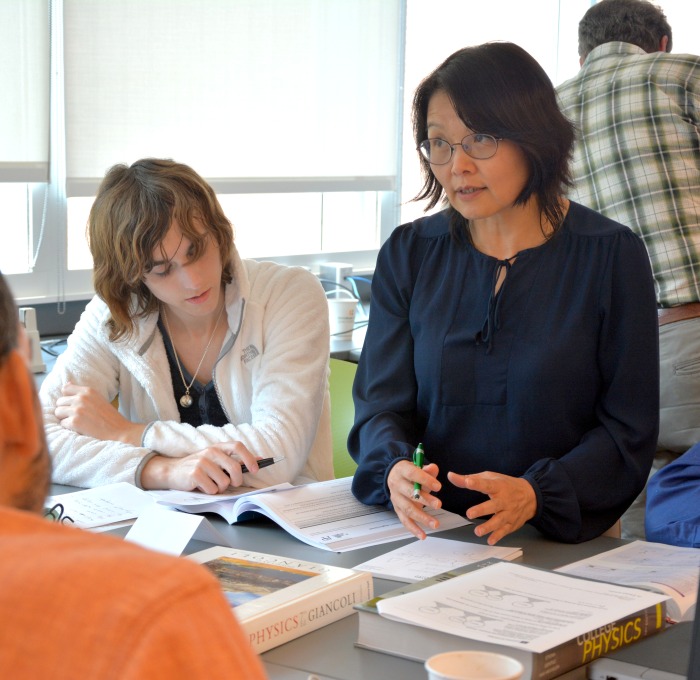 Students working with professor in a classroom