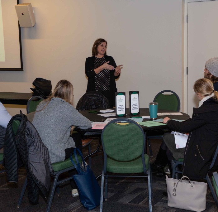 Faculty addressing students about education programs at grad info session