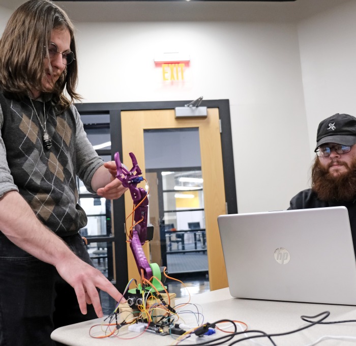 Students in Electronics Engineering Capstone Project working with computer and creature