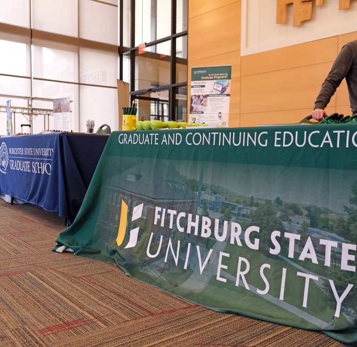 SGOCE, Worcester State and ULowell tables at the Graduate Fair in Hammond Hall Main Lounge