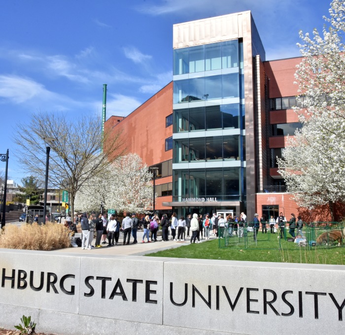 Front of Hammond Hall with sign and flowering trees during spring week festivities