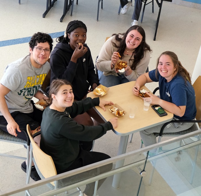 Students from above sitting at table in Hammond eating french fries