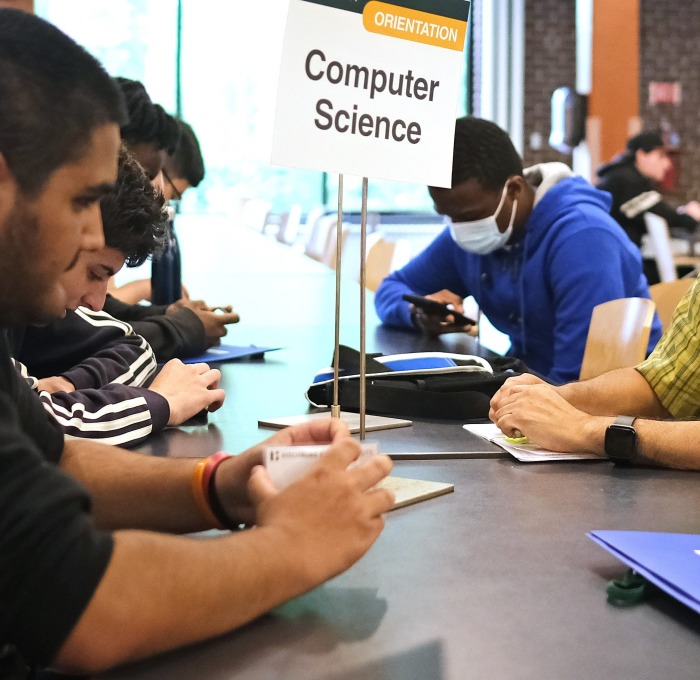 Computer Science student and teacher at orientation at table