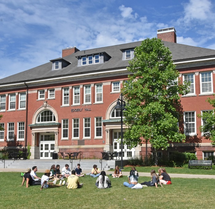 Group of students sitting in grass on the quad in front of Edgerly