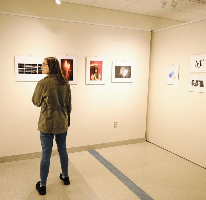 Female student in art gallery looking at exhibits