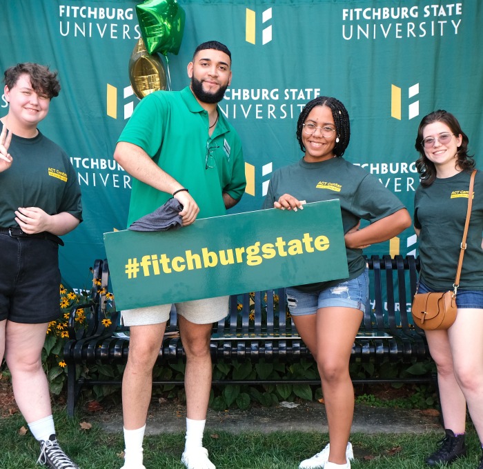 ACT Counselors welcoming students at orientation on quad with photo props