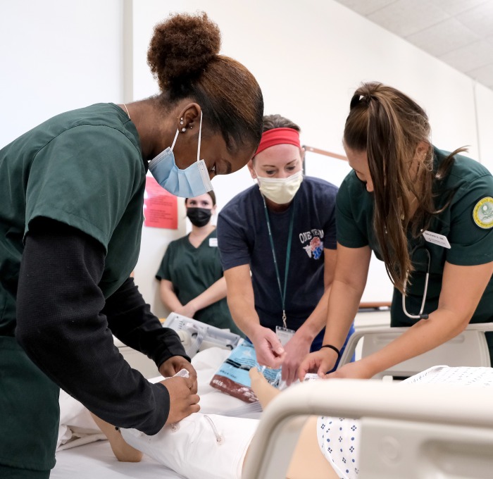 Nursing students and instructor working on patient during a catheter lab