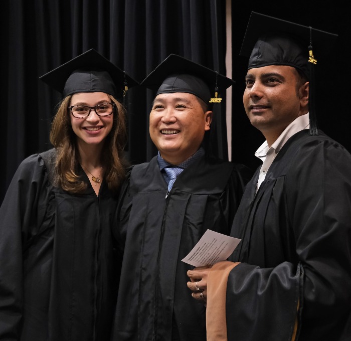 Graduate business students posing waiting to cross stage