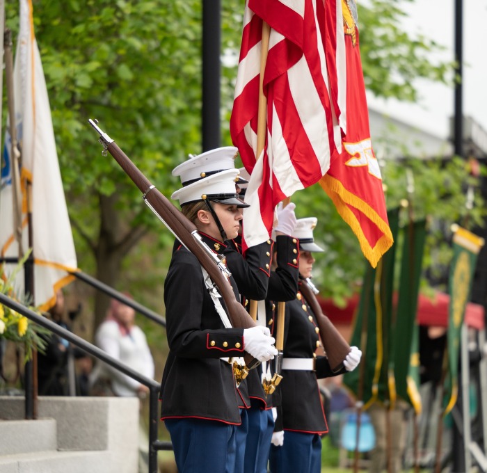 Color guard at undergrad commencement holding flags in front of Edgerly 